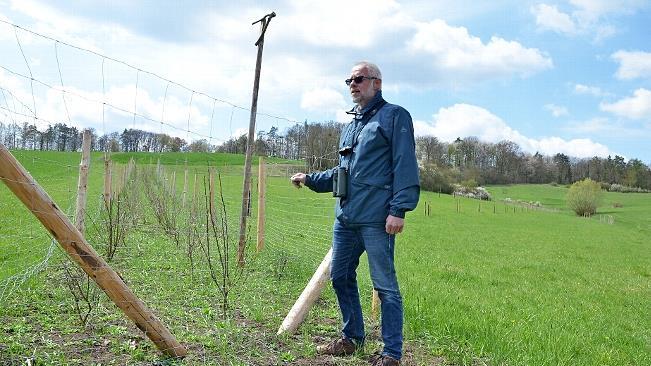 Frank Reißenweber zeigt eine Fläche bei Großwalbur, auf der vom LPV eine Hecke erweitert und eine Streuobstwiese angelegt wurde.