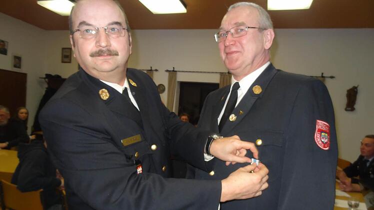 Für 40 Jahre Dienst in der Freiwilligen Feuerwehr heftet Kreisbrandrat Roland Eckert dem Kreisbrandinspektor Bernd Rüdiger die Goldene Ehrennadel ans Revers.