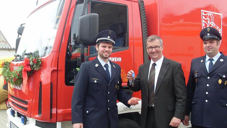 Feierlich übergab Bürgermeister Ernst Nickel den Schlüssel an die Feuerwehr Geiselwind, vertreten durch 2. Kommandanten Benedikt Rückel (links) und Vereinsvorsitzenden Sebastian Rückel (rechts). Foto: Nathalie Zapf