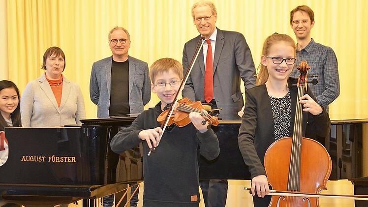 Die siegreichen Kinder Hanna Le (am Flügel) sowie Felix und Clara Pastowksi mit (hinten von links) Musikschulleiterin Margit Denk, Lehrer Volkmar Studtrucker, Bürgermeister German Hacker und Lehrer Matthias Schick  Foto: Bernhard Panzer