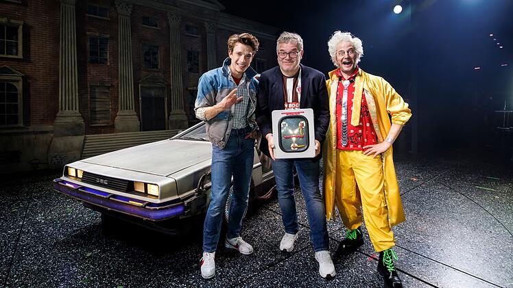 Gastauftritt in Hill Valley: Moderator Elton (Mitte) &uuml;bernimmt Ende Juli die Rolle des Schuldirektors Strickland in "Zur&uuml;ck in die Zukunft - Das Musical" und ist darin an der Seite von Raphael Gro&szlig; als Marty McFly (links) und Jan Kersjes als Doc Brown zu sehen.