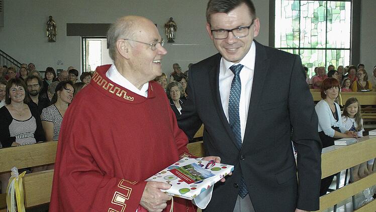 Bürgermeister Armin Warmuth überreichte dem "lieben Joshi" ein Präsent zum "goldenen" Priesterjubiläum. Foto: Winfried Ehling