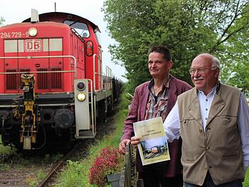 Wolfgang Bleiweis (links) und der Mühlhäuser Wolfgang Schürmann sind die Autoren des neuen Buches. Wie bestellt rollt gerade ein Güterzug an, der das Schlüsselfelder Unternehmen Schwarz mit Draht beliefert.  Foto: Evi Seeger