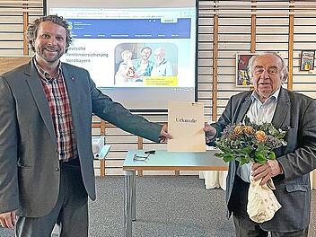 Heinz Hausmann (rechts) erhielt für sein jahrzehntelanges ehramtliches Engagement von Björn Wortmann, dem alternierenden Vorsitzenden der Vertreterversammlung der DRV Nordbayern, eine Urkunde und einen Bildband überreicht.