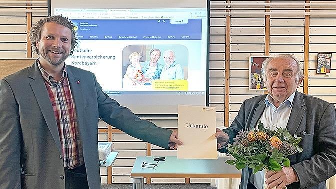 Heinz Hausmann (rechts) erhielt für sein jahrzehntelanges ehramtliches Engagement von Björn Wortmann, dem alternierenden Vorsitzenden der Vertreterversammlung der DRV Nordbayern, eine Urkunde und einen Bildband überreicht.
