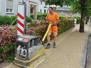 Bauhofmitarbeiter Eduard Ameis planiert den Gehweg die Steine als Stplperfalle wurden entfernt.  Foto: Petra Malbrich