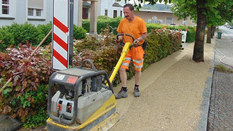 Bauhofmitarbeiter Eduard Ameis planiert den Gehweg die Steine als Stplperfalle wurden entfernt.  Foto: Petra Malbrich