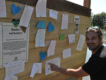 Thomas Beyer befestigt einen Zettel an der "Klagemauer" von Go&szlig;mannsdorf. Foto: Martin Schweiger