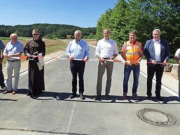 Mit dem Banddurchschneiden am Ortsausgang von Leutzdorf gaben Bürgermeister Hanngörg Zimmermann, seine Stellvertreter Georg Bauernschmidt und Manfred Hänchen, Pfarrer Ludwig Mazur und Vertreter des Planungsbüros und der Baufirma die Straße für den Verkehr frei.  Foto: Thomas Weichert