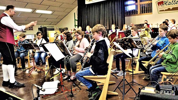 Die Orchesterschule Pressig-Stockheim ist zu einer Talentschmiede für Kinder und Jugendliche geworden. Mit im Bild Dirigent Roman Steiger, Neukenroth. Die Aufnahme entstand zum 20-jährigen Bestehen in der Neukenrother Zecherhalle 2019. Foto: Gerd Fleischmann
