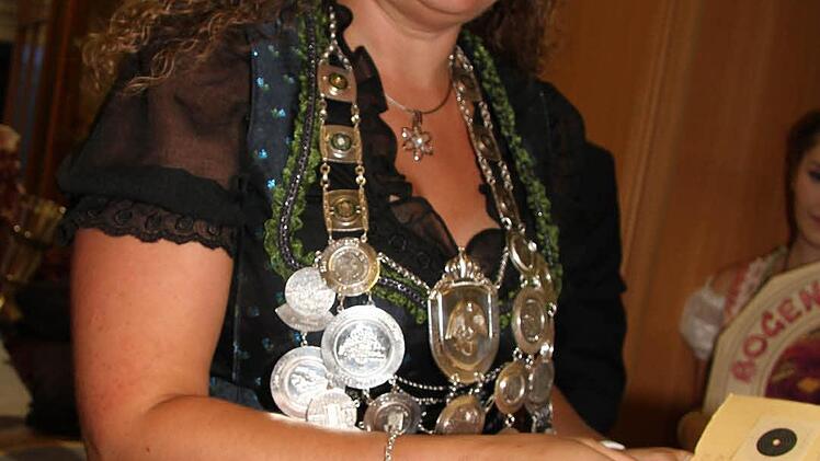 Moderne Majestäten können beides: Im Glitzerdirndl zeigt Anja Lochmüller ihr Siegerblatt mit einem 13,1 Teiler und 10,9 Ringen stach sie alle anderen beim Luftgewehrschießen aus - und wurde Schützenkaiserin .