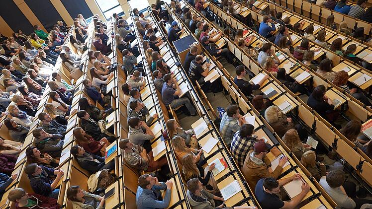 Studenten sitzen bei der Erstsemesterbegrüßung am Campus Koblenz der Universität Koblenz-Landau im großen Hörsaal. Foto: Thomas Frey/dpa