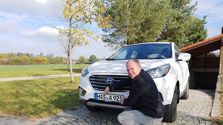 Ein Traum geht in Erfüllung: Thomas Hümmer bringt das neue Kennzeichen an sein wasserstoffbetriebenes Auto an. privat