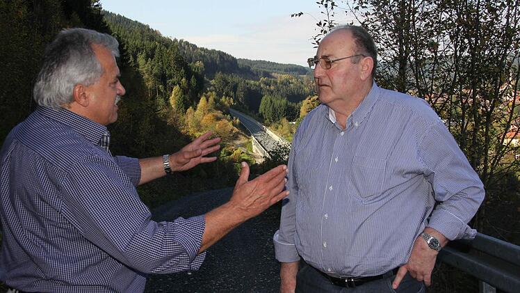 Peter Hänel (links) und Kurt Pröstler (rechts) erinnern sich an den Bau der Ortsumgehung Wallenfels (im Hintergrund). Foto: Corinna Igler