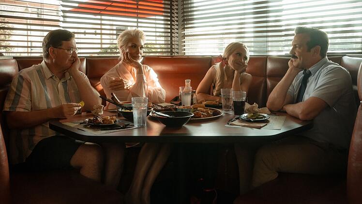 Spare Ribs f&uuml;r die G&auml;ste: Leslie (Jeremy Swift, links) Clubchefin Rebecca (Hannah Waddingham, zweite von links) und Keeley (Juno Temple) sind extra nach Kansas geflogen, um Ted Lasso zur R&uuml;ckkehr zu AFC Richmond zu &uuml;berreden.