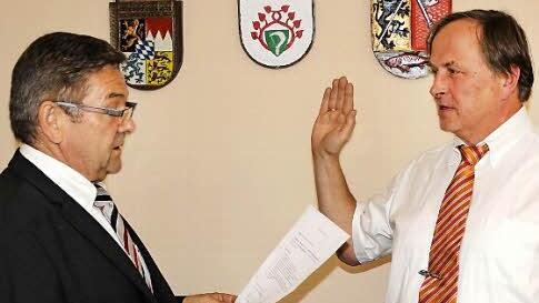 Der Senior des Gemeinderats, Peter Schmitt, vereidigt Gerhard Riediger als neuen Bürgermeister der Gemeinde Unterleinleiter.
