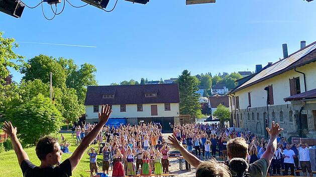 Hoch die H&auml;nde! Im Vordergrund sind von hinten zwei der Thormann-Br&uuml;der, Markus und Tobias, zu sehen, wie sie der gut gelaunten Menge auf dem Hof der Familie Benckiser einheizen. Der dritte Hinterkopf geh&ouml;rt einem Kameramann des Bayerischen Rundfunks. Der Beitrag ist in der Mediathek der Abendschau zu sehen. Foto: Philipp Thormann