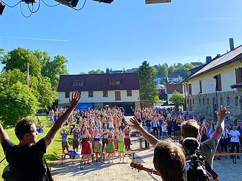 Hoch die Hände! Im Vordergrund sind von hinten zwei der Thormann-Brüder, Markus und Tobias, zu sehen, wie sie der gut gelaunten Menge auf dem Hof der Familie Benckiser einheizen. Der dritte Hinterkopf gehört einem Kameramann des Bayerischen Rundfunks. Der Beitrag ist in der Mediathek der Abendschau zu sehen. Foto: Philipp Thormann