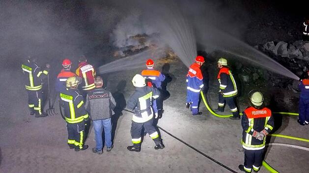 "Wasser marsch", um die brennenden Paletten abzul&ouml;schen. Mit im Bild einige Feuerwehrleute, die das gekonnte Eingreifen der Jugendwehr beobachteten.