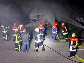 "Wasser marsch", um die brennenden Paletten abzulöschen. Mit im Bild einige Feuerwehrleute, die das gekonnte Eingreifen der Jugendwehr beobachteten.