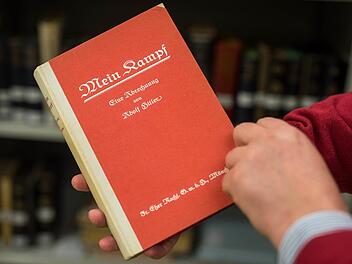 Bibliotheksleiter Daniel Schlögl blättert in den Räumen vom Institut für Zeitgeschichte in München in der Erstausgabe von Adolf Hitlers "Mein Kampf" aus dem Jahr 1925.  Foto: Matthias Balk, dpa