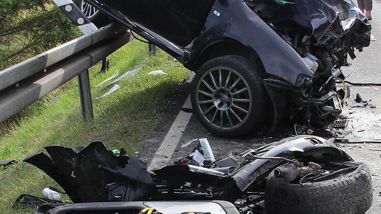 Felge und Antriebswelle des Pickup, dahinter Stoßstange und linkes Vorderrad des Audi.