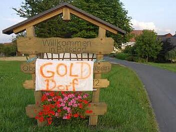 Die Pülsdorfer zeigen der Welt, was sie seit vergangener Woche sind: ein Gold-Dorf! Fotos: Berthold Köhler