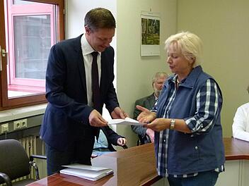 Ann Rose-Palauneck übergibt die Unterschriftslisten der Neubau-Gegner, eigentlich "Baumfreunde" an Bürgermeister Marco Steiner. Foto: Lothar Weidner