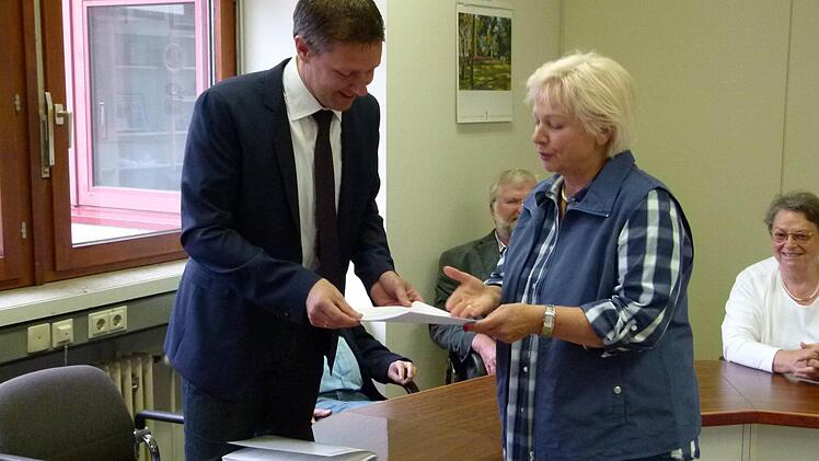 Ann Rose-Palauneck übergibt die Unterschriftslisten der Neubau-Gegner, eigentlich "Baumfreunde" an Bürgermeister Marco Steiner. Foto: Lothar Weidner