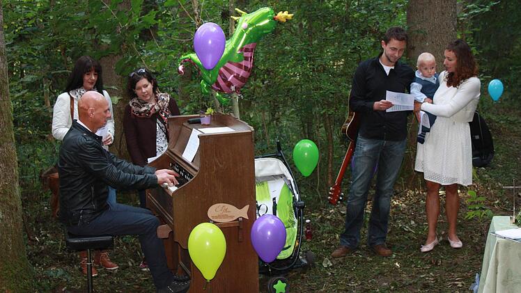 Papa Frank spielt auf dem extra herbeigeschafften Harmonium bei der Waldtaufe seines Sohns Elljot. Foto: Henning Schuster