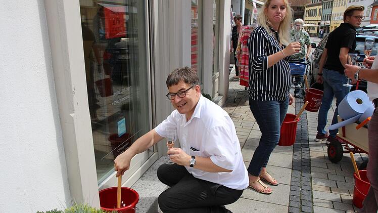 So geht's vermutlich viel leichter: Janis Franz hat den freiwilligen Fensterputzern, hier Christian Müller, Sekt spendiert. Foto: Simone Bastian