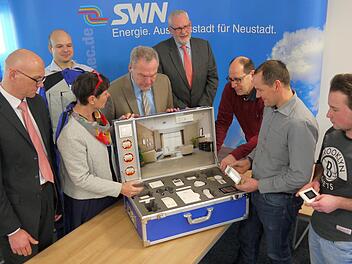 Klein, aber oho: Schon der Blick in den Musterkoffer der Stadtwerke reicht, um einen ersten Eindruck über die schier unendlichen Möglichkeiten moderner Technik zur Erleichterung des alltäglichen Wohnens zu bekommen. Volker Hoess, Simon Kuchenreuther, Sabine Brückner-Zahneisen, Frank Rebhan, Armin Münzenberger, Detlef Heerlein, Marco Höhn und Marcel Marx (von links) sind jedenfalls hoch interessiert. Foto: Berthold Köhler