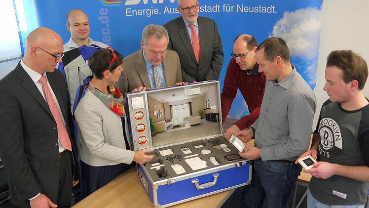 Klein, aber oho: Schon der Blick in den Musterkoffer der Stadtwerke reicht, um einen ersten Eindruck über die schier unendlichen Möglichkeiten moderner Technik zur Erleichterung des alltäglichen Wohnens zu bekommen. Volker Hoess, Simon Kuchenreuther, Sabine Brückner-Zahneisen, Frank Rebhan, Armin Münzenberger, Detlef Heerlein, Marco Höhn und Marcel Marx (von links) sind jedenfalls hoch interessiert. Foto: Berthold Köhler