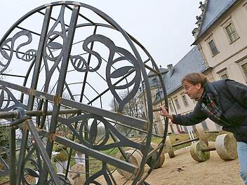 Peter Groh dreht das neue "Mühlrad" der JVA Ebrach. Im Hintergrund ist der Rest des    "Kunst am Bau"-Projektes  zu sehen.  Fotos: Barbara Herbst