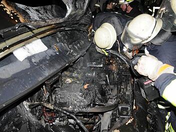 Feuerwehrleute schauen in den Wagen, in dem das Feuer wütete.  Fotos: Gerold Snater