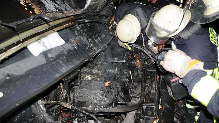 Feuerwehrleute schauen in den Wagen, in dem das Feuer wütete.  Fotos: Gerold Snater