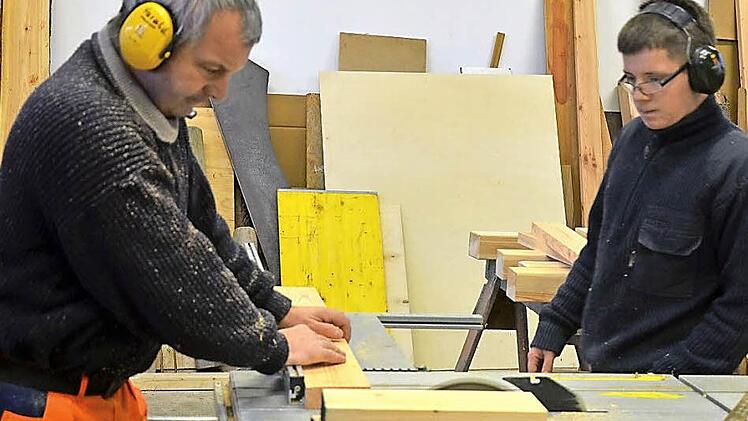 Florian Puff (rechts) schaut seinem "Meister" Harald Hebeis in der Schreinerwerkstatt des Strullendorfer Bauhofs aufmerksam zu. Foto: Andrea Spörlein