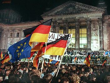 Rund eine Million Menschen feierten in der Nacht zum 3. Oktober 1990 in Berlin wie hier vor dem Reichstagsgebäude die wiedergewonnene deutsche Einheit. Am 03.10.2015 jährt sich die Deutsche Wiedervereinigung zum 25sten Mal. Foto: Wolfgang Kumm/dpa