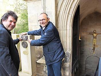 Uwe Frank, Ortskurator der Deutschen Stiftung Denkmalschutz (links), und Dekan Roland Huth suchen vor dem Eingang zur Koháry-Gruft von St. Augustin den passenden Platz für die neue Plakette. Foto: Ulrike Nauer