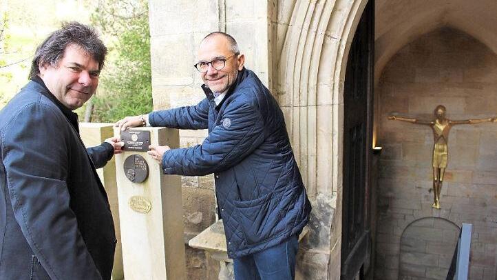 Uwe Frank, Ortskurator der Deutschen Stiftung Denkmalschutz (links), und Dekan Roland Huth suchen vor dem Eingang zur Koháry-Gruft von St. Augustin den passenden Platz für die neue Plakette. Foto: Ulrike Nauer
