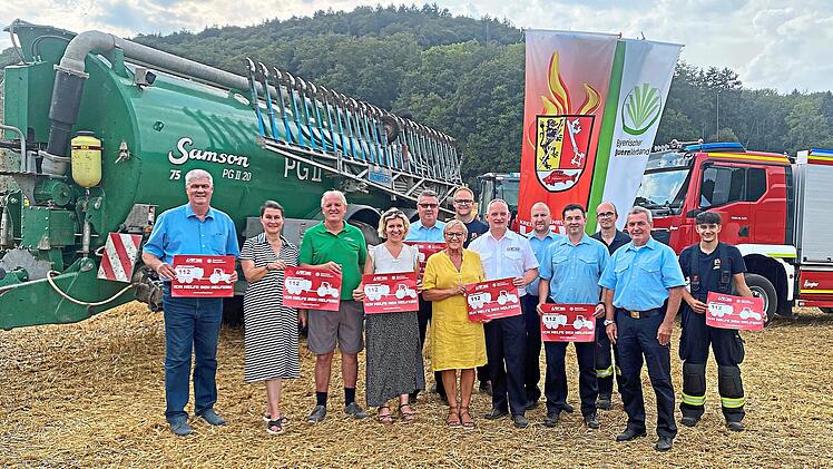 Die Initiatoren stehen vor einem riesigen Wasserwagen und einem Feuerwehrauto.