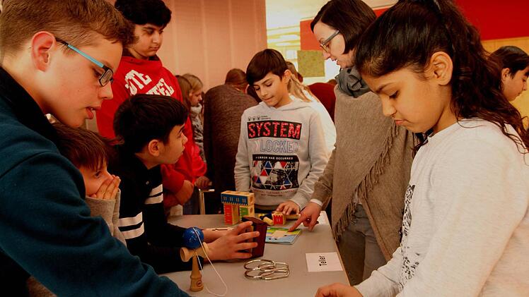 Lehrerin Elke Neidlein (2. Von rechts) verfolgt das Knobeln bei ihren Schülern. Foto: Günther Geiling