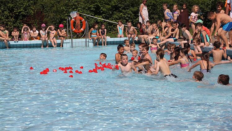 Rote Quietsch-Entchen warf Rudi Rath ins Wasser, auf die sich die Kinder dann stürzen.