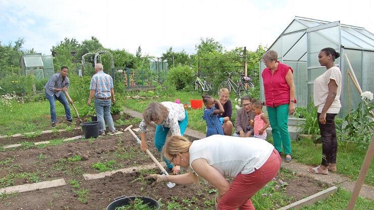 Akila Tekel (links) und seine Ehefrau Abeba Tesfayaber (rechts) waren mit ihren Kindern Loza und Eldanan zur Garteneröffnung gekommen und packten mit an. Mit dabei waren auch Christiane Zinoni-Peschel (Dritte von links), Erna Rank-Kern und Andrea Schiele-Eberlein (Hinten, Fünfte und Vierte von rechts).  Foto: Helke Renner