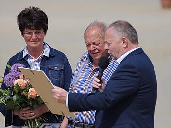 Landrat Thomas Bold (rechts) verlieh den Sport-Ehrenbrief des Landkreises an Otto Müller  vom Reiterhof Rhön (Mitte). Blumen gab es für Ehefrau Irma Müller. Foto: Sebastian Schmitt