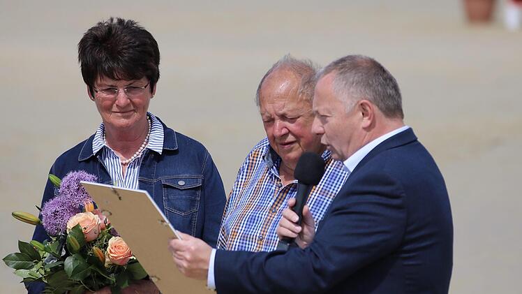 Landrat Thomas Bold (rechts) verlieh den Sport-Ehrenbrief des Landkreises an Otto Müller  vom Reiterhof Rhön (Mitte). Blumen gab es für Ehefrau Irma Müller. Foto: Sebastian Schmitt