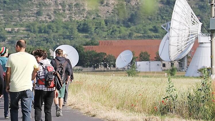 Die Teilnehmer laufen auf dem Feldweg neben der Erdfunkstelle.