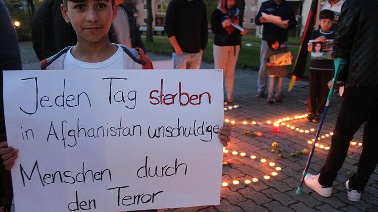 Milat Nuri, der vor knapp einem Jahr von einem Sprengsatz verletzt wurde, hält bei der Trauerfeier ein Plakat.  Foto: Markus Häggberg