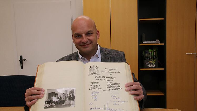 Bürgermeister Michael Kastl zeigt den Eintrag im Goldenen Buch der Stadt Münnerstadt. Vor 50 Jahren unterzeichneten die Bürgermeister der umliegenden Gemeinden den Eingliederungsvertrag und verewigten sich im Goldenen Buch. Foto: Thomas Malz