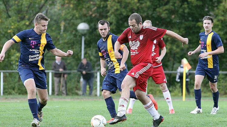 Stefan Meinert (rot) vom TSV Staffelbach gegen Johannes Bergen (dahinter) und Jan-Luca Kabitz (l.); rechts Michael Münch